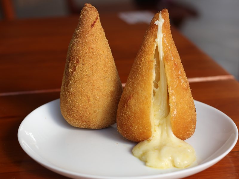 Coxinha de queijo do Kiosque Roseira aberta, com o queijo escorrendo