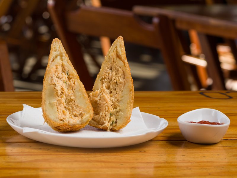 Coxinha de frango do Kiosque Roseira aberta ao meio no prato