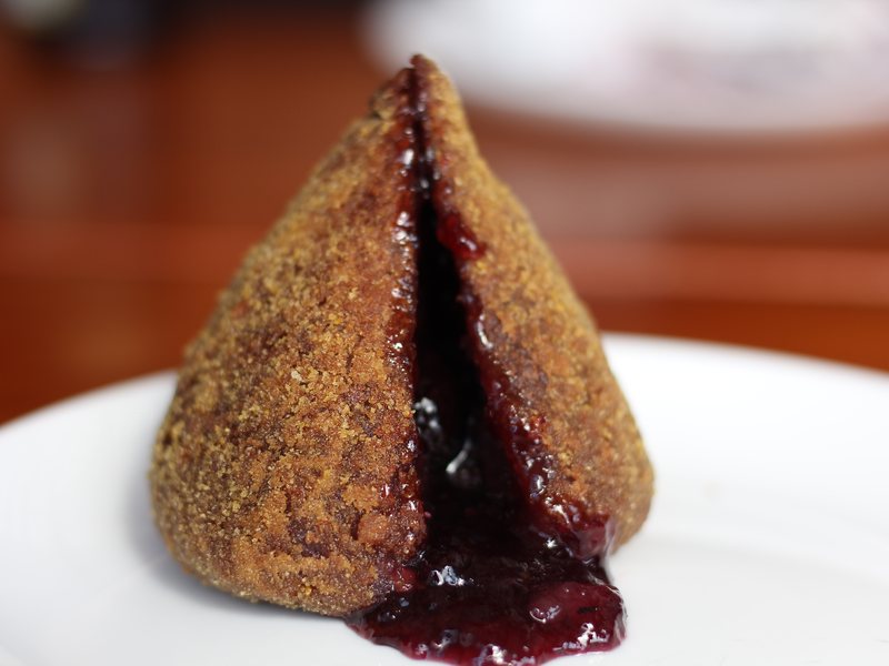 Coxinha de uva do Kiosque Roseira aberta, com a geleia escorrendo